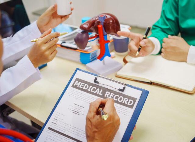 Doctors gather at a hospital desk to discuss treatment plans for liver diseases like hepatitis B